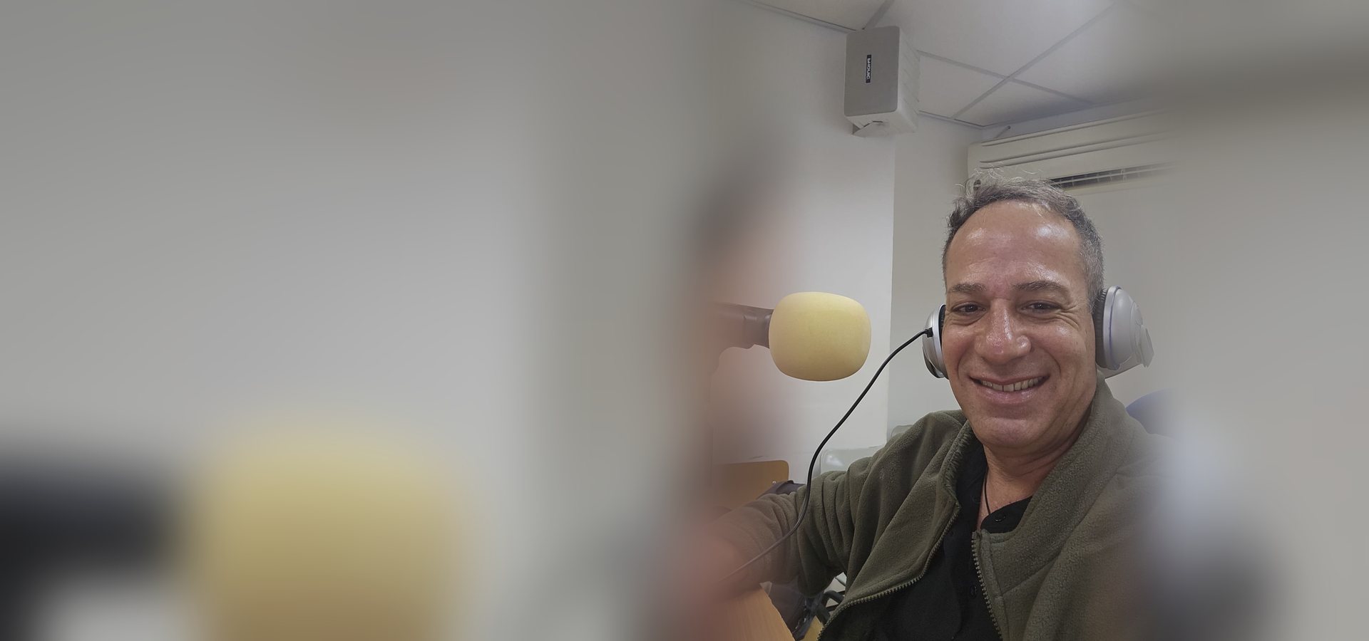 אלון שמש באולפן ההקלטות, עם אוזניות מול המיקרופון